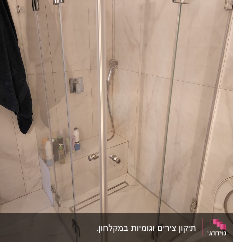 מקלחון זכוכית עם ראש מקלחת ומוצרי טיפוח